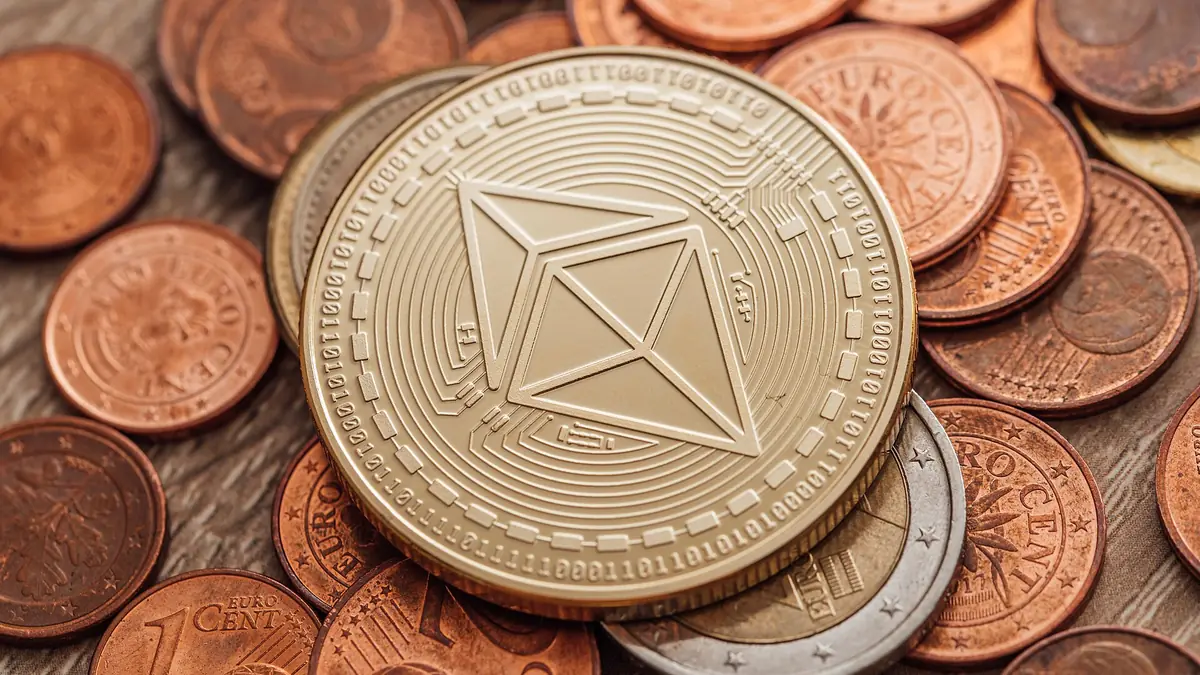 Close-up of a physical Ethereum coin lying on euro cent coins