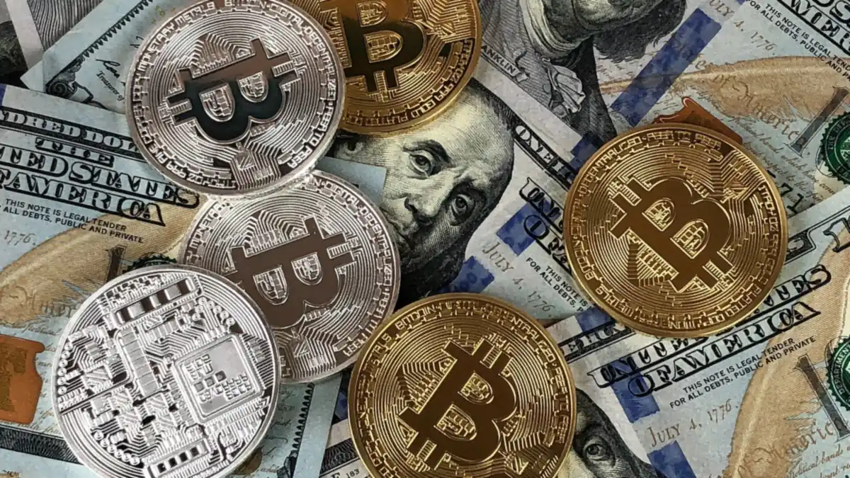 Pile of gold and silver bitcoin coins on US dollar bills