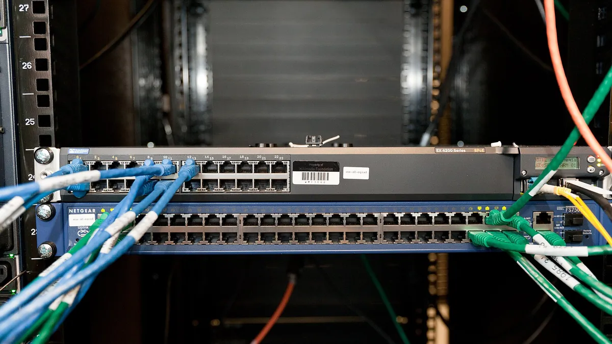 Network switch in a server rack with blue and green cables